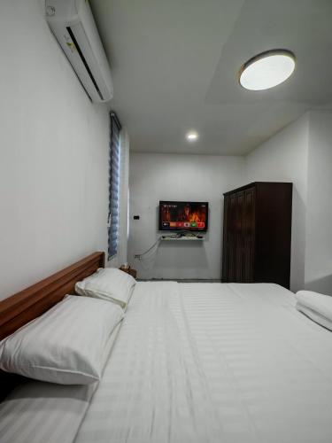 a bedroom with a bed and a tv on the wall at Windy Pool Villa Pattaya Private Entire house in Ban Bang Lamung