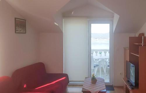a living room with a red couch and a window at 3 Bedroom Lovely Apartment In Rogotin-Ploce in Rogotin
