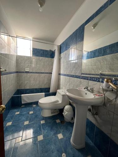 a blue and white bathroom with a sink and a toilet at HOTEL AREQUIPA in Nazca