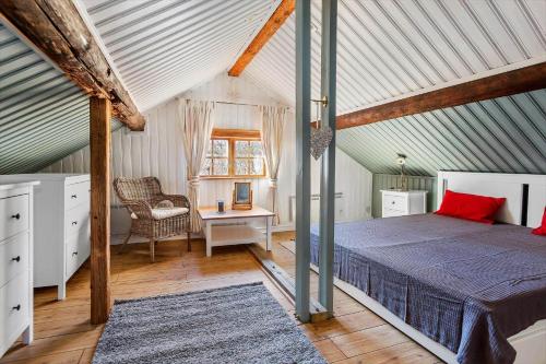 1 dormitorio con 1 cama y 1 silla en el ático en KAL529-Virserum-Dala-5, en Virserum