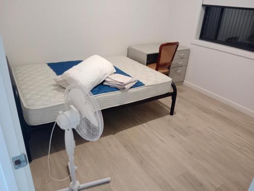 Habitación con cama con ventilador y escritorio. en A private room, en Evandale