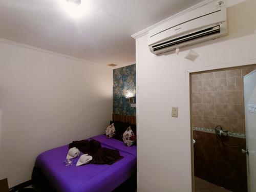 Zimmer mit einem lila Bett in einem Zimmer in der Unterkunft Ketapang Residence Hotel in Jakarta