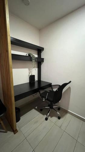 a desk and a chair in a room at Comfortable apartment in Acacias, San Ignacio in Tegucigalpa