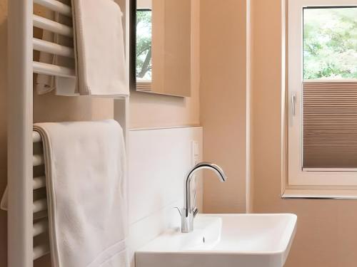 Ferienwohnung am Wall في سوست: حمام مع حوض أبيض ونافذة