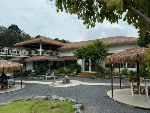een huis met een rieten dak en een terras bij Hidden Haven Resort Koh Lanta in Ko Bu Bu
