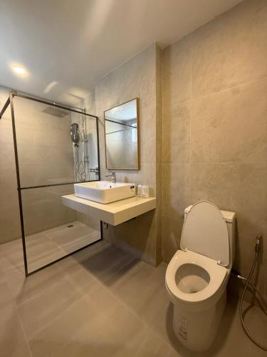 a bathroom with a toilet and a sink and a shower at Hidden Haven Resort Koh Lanta in Ko Lanta