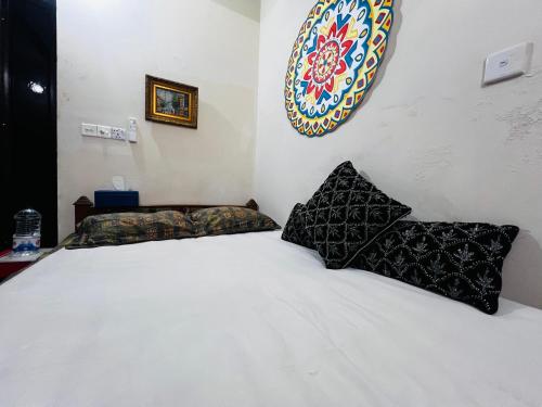 a bedroom with a white bed with two pillows at Gulshan Guest House in Dhaka