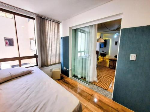 ein Schlafzimmer mit einem Bett und einem großen Glasfenster in der Unterkunft Apartamento Centro de Capão da Canoa in Capão da Canoa