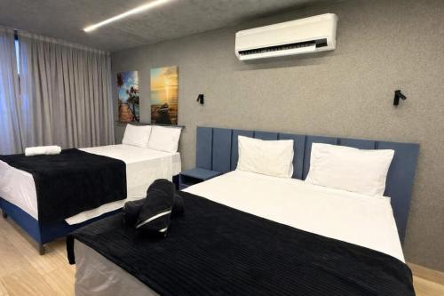 a hotel room with two beds and a air conditioner at Setai Yatch - Praia in João Pessoa