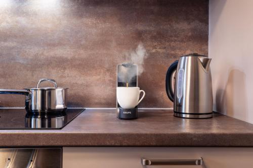 eine Kaffeemaschine und eine Kaffeekanne auf der Theke in der Unterkunft Weisser Ochsen - smart living by corents in Schwäbisch Gmünd