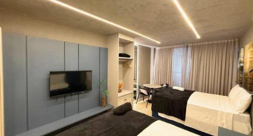 a bedroom with a bed and a television on a wall at Setai Yatch - Praia in João Pessoa