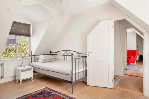 um quarto com uma cama e uma cadeira vermelha em SKA694-Hoeganaes-Hustoftavaegen-95 em Höganäs