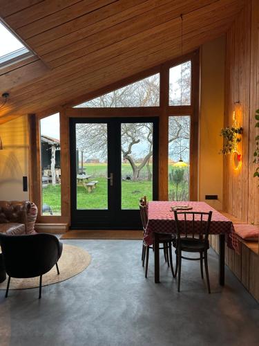 a dining room with a table and chairs and windows at PieterBuur in Pieterburen