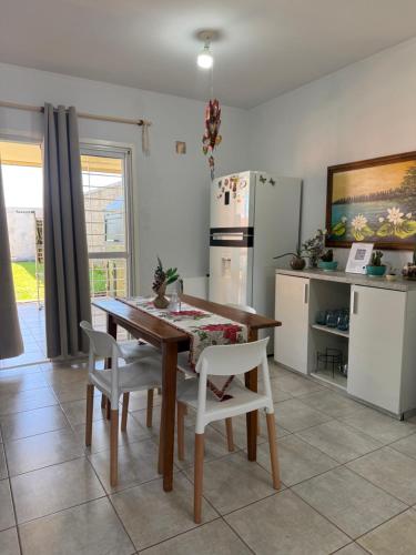 波萨达斯Casa Yvy Guazú的厨房配有木桌和白色椅子