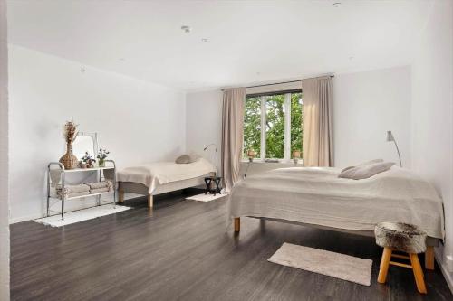 a white bedroom with a large bed and a window at OGO781-Mjoelby-Norrby-Naesloesegard-1 in Mjölby