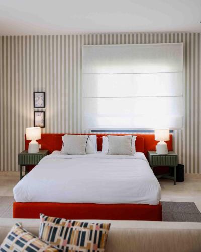 a bedroom with a large bed and two tables with lamps at Villette Serviced Apartments in Sodic New Cairo in New cairo