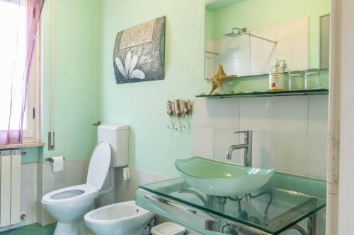 a bathroom with a glass sink and a toilet at Casa Vacanza TDL in Torre del Lago Puccini