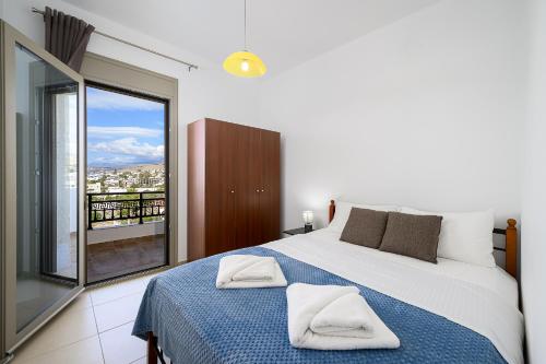 ein Schlafzimmer mit einem großen Bett und einem Balkon in der Unterkunft Family Home, with Sea & Mountain view in Kalamaki