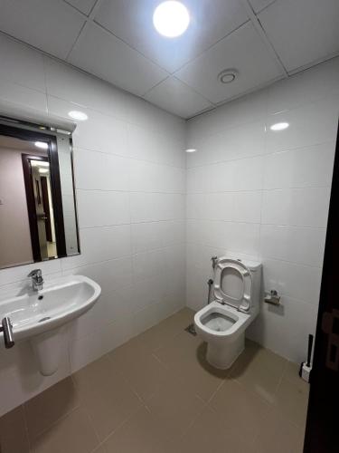 a bathroom with a toilet and a sink at Mazaya VIP Stay in Mawāliḩ