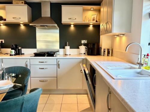 a kitchen with white cabinets and a sink at FREE PARKING - Prime York City Centre Apartment near Minster with River View in York