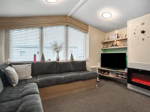 een woonkamer met een bank en een flatscreen-tv bij Ali B's Craig Tara in Ayr