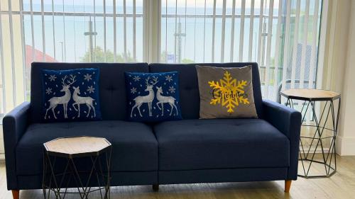 un canapé bleu avec des coussins bleus et dorés dans l'établissement Seaview West Coast - Exceptional - 2 Bedrooms Sleeps 5 -Stunning Sea Views - 500 metres to Beach, à Bournemouth