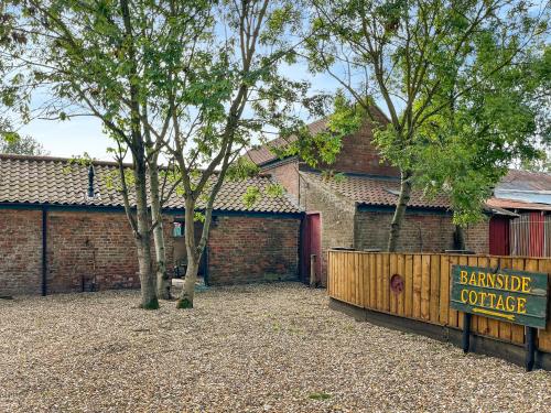 ein Schild vor einem Gebäude mit einem Zaun in der Unterkunft Barnside Cottage - Uk50574 in Hayton