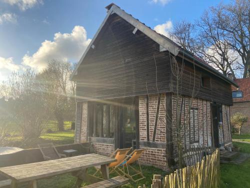 Maison au bord de riviere , proche de la mer- spa semi rigide plein air en option في Bacqueville-en-Caux: منزل صغير أمامه طاولة نزهة