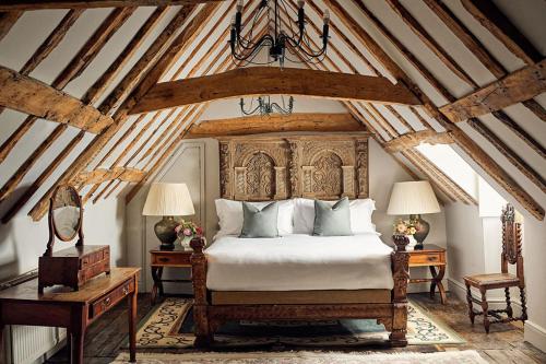 Un dormitorio con una cama grande con cabecero de madera. en Chilston Park Hotel, en Maidstone