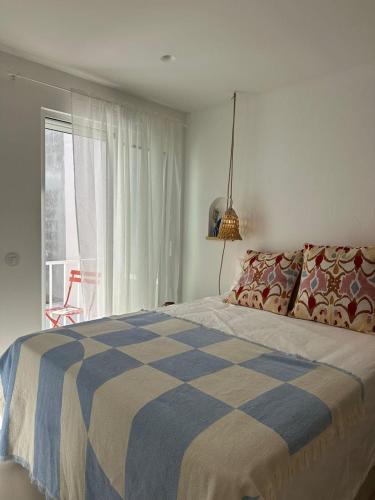a bedroom with a blue and white bed and a window at Casa Dar Alma in Vila Real de Santo António