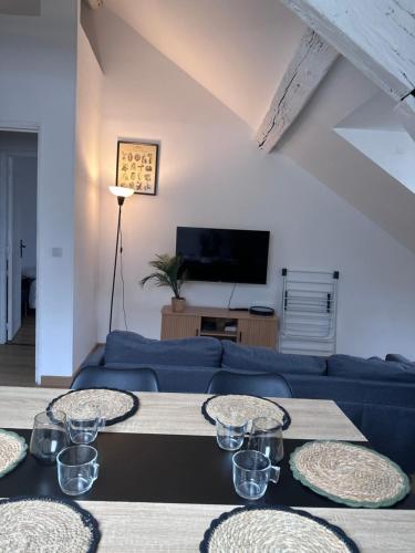 een woonkamer met een blauwe bank en een tafel bij Luxe Centre Orléans Chatelet I Exclusivité in Orléans