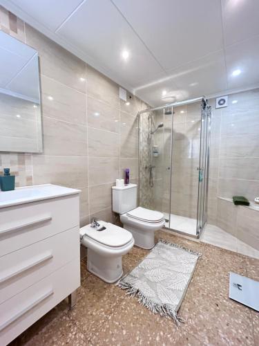 a bathroom with a toilet and a shower and a sink at On the Beach Oliva in Oliva