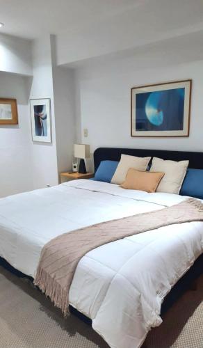 a bedroom with a large white bed with a blue headboard at Residence Polanco, Security24h, Balcony, Pool, Gym, CarPark in Mexico City