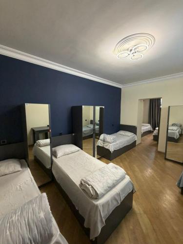 a bedroom with three beds and a blue wall at Guesthouse MA in Yerevan