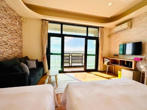 une chambre avec deux lits, un canapé et une télévision dans l'établissement Sun Shine B&B, à Hengchun Old Town