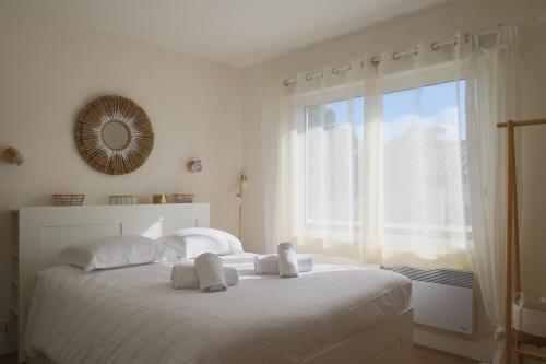 Un dormitorio blanco con una cama grande y una ventana. en T2, 50 m beach, balcony with sea view, en La Teste-de-Buch