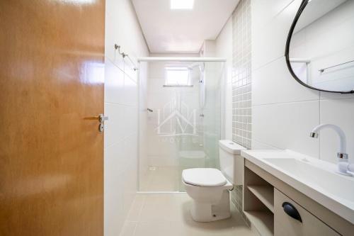 ein weißes Badezimmer mit Toilette und Dusche in der Unterkunft Cobertura 07 Antares Bombinhas in Bombinhas