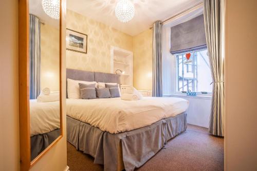 a bedroom with a large bed and a mirror at Little Net House - Pittenweem in Pittenweem