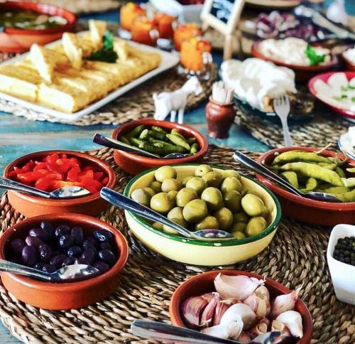 einen Tisch mit vielen Schalen verschiedener Arten von Lebensmitteln in der Unterkunft Posada del Marqués I A Slow Design Hotel in Esporles