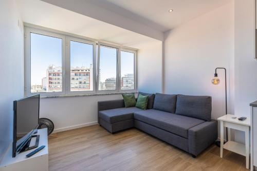 a living room with a couch and some windows at Eua 112 II in Lisbon