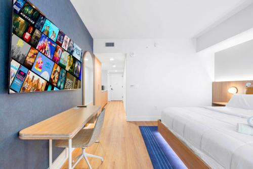 een slaapkamer met een bed, een bureau en een tv bij Luxury Studio & City Views in Miami