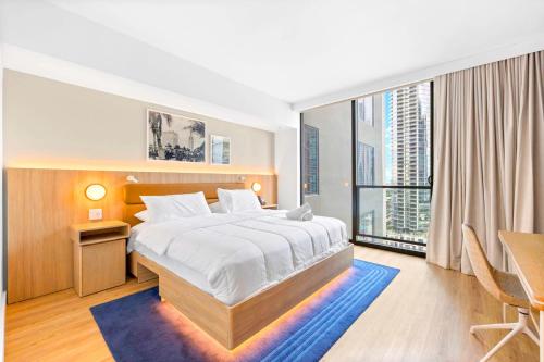 een slaapkamer met een bed en een tafel en een groot raam bij Luxury Studio & City Views in Miami
