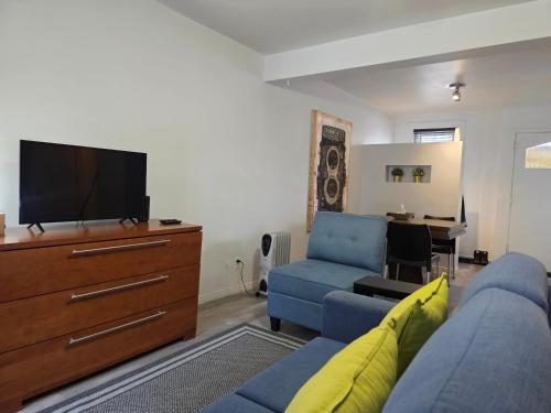 a living room with a blue couch and a flat screen tv at STUDIO SAINT-ROCH in Quebec City