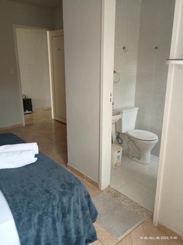 a bathroom with a bed and a toilet in a room at Pousada Fonte da Samaritana in Vila Velha