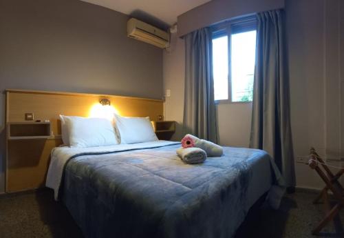 a hotel room with a bed with a teddy bear on it at Hotel JBJ in Mendoza