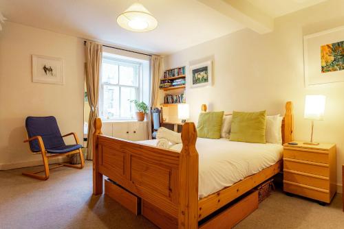 a bedroom with a wooden bed and a blue chair at Harbour View Apartment - Crail in Crail