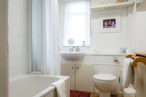 a white bathroom with a toilet and a sink at Harbour View Apartment - Crail in Crail