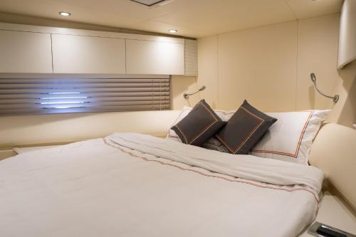 a bedroom with a large white bed with two pillows at Yacht Azimut Atlantis 50 in Dubai