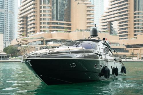 a black boat in the water with buildings at Yacht Azimut Atlantis 50 in Dubai