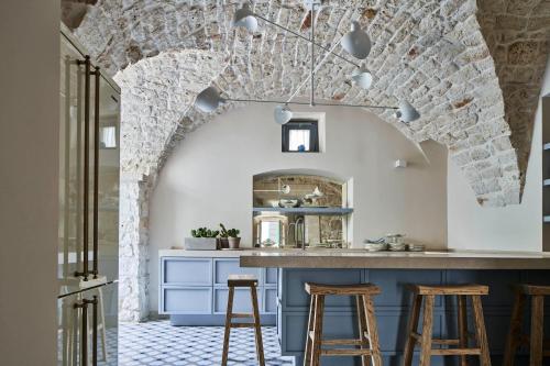 een keuken met een blauw eiland met barkrukken bij Dimora Cocchi in Carovigno
